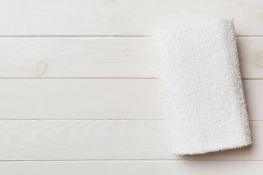 Renkli arkaplanda kopyalama alanı olan beyaz havluların üst görünümü.