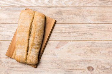Tahtanın üzerinde beyaz ahşap zemine karşı taze pişmiş ekmek. Kopya alanı olan üst görünüm ekmeği.