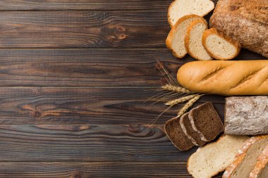 Ev yapımı doğal ekmek. Arka plan olarak farklı taze ekmek türleri, kopya alanı ile üst görünüm.