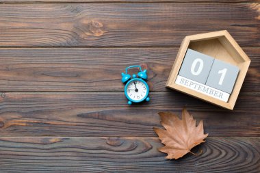 Kopya alanı ile Eylül üstü görünümü için takvim. 1 Eylül tarihli ahşap takvim bloğu ve düşen sonbahar yaprakları arka planı.