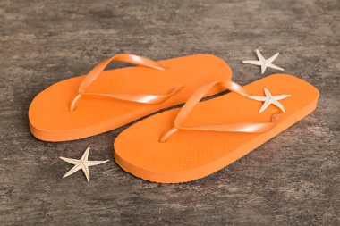 Plaj aksesuarları. Renkli arka planda parmak arası terlik ve denizyıldızı. Üst görünüm Kopyalama alanı ile modelle.