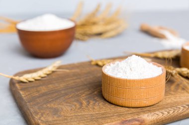 Tahta kasede buğday unu ve renkli arka planda buğday dikenleri. dünya buğday krizi.