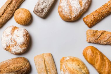 Ev yapımı doğal ekmek. Arka plan olarak farklı taze ekmek türleri, kopya alanı ile üst görünüm.