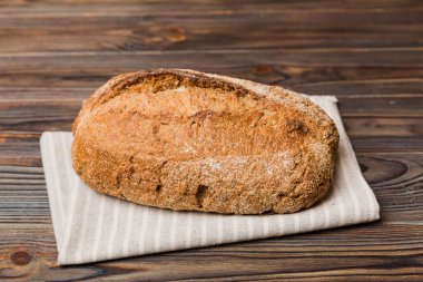 Kırsal masa manzaralı peçeteli taze pişmiş ekmek. Sağlıklı beyaz ekmek izole edilmiş..