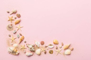 Yaz zamanı konsepti düz kompozisyon ile güzel deniz yıldızları ve deniz kabukları renkli tablo üzerinde yatıyordu, metin için metin alanı ile üst görünüm.