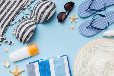 Kadın mayo ve plaj aksesuarları renkli arka plan yaz seyahati konseptine düz bir görünüm kazandırıyordu. Bikini mayo, hasır şapka ve deniz topuklu ayakkabı. Üst görünümü kopyala.