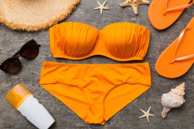 Kadın mayo ve plaj aksesuarları renkli arka plan yaz seyahati konseptine düz bir görünüm kazandırıyordu. Bikini mayo, hasır şapka ve deniz topuklu ayakkabı. Üst görünümü kopyala.