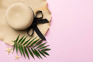 Summer holidays. Summer concept with straw hat and tropical leaf. Flat lay, top view, copy space.