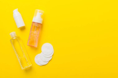 Kozmetikleri çıkarmak ve renkli arkaplandaki deriyi temizlemek için Micellar suyu ve diskleri temizler. Üst görünümü kopyala.