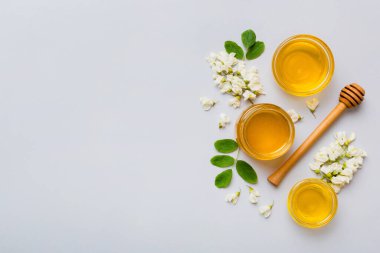 Akasya çiçekli ve yapraklı bal kavanozu. Taze bal üst görünüm düz yatıyordu.