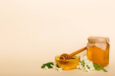 robinia honey bollte with acacacia flomes on color table.