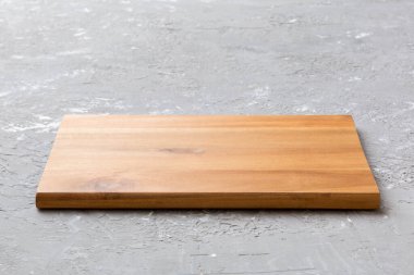 Çimento arka planında tahta kesme tahtası manzarası. Tasarımın için boş boşluk.