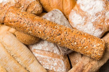 Ev yapımı doğal ekmek. Arka plan olarak farklı taze ekmek türleri, kopya alanı ile üst görünüm.