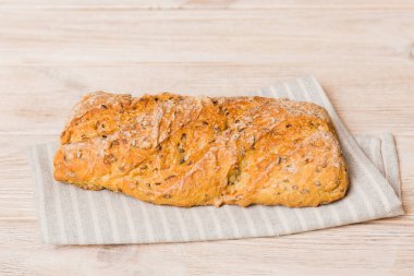 Kırsal masa manzaralı peçeteli taze pişmiş ekmek çeşitleri. Sağlıklı mayasız ekmek. Fransız ekmeği.