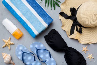 Kadın mayo ve plaj aksesuarları renkli arka plan yaz seyahati konseptine düz bir görünüm kazandırıyordu. Bikini mayo, hasır şapka ve deniz topuklu ayakkabı. Üst görünümü kopyala.