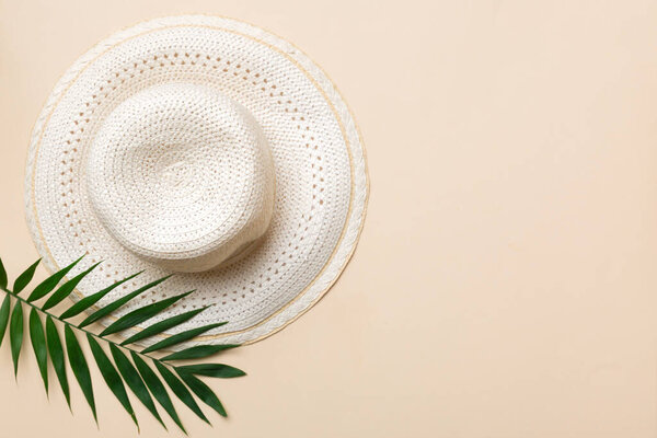 Summer holidays. Summer concept with straw hat and tropical leaf. Flat lay, top view, copy space.