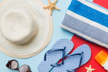 Plaj aksesuarları hasır şapka ve deniz kabuğu renkli masada. Yaz konsepti arka planı.