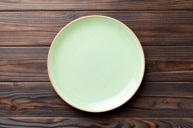 Ahşap zemindeki boş mavi tabağın üst görüntüsü. Tasarımın için boş boşluk.