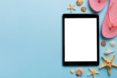 Renkli arka planda tablet ve plaj aksesuarlarıyla düz kompozisyon. Boş ekran ile tablet bilgisayarı kopyalama alanı ile maket.