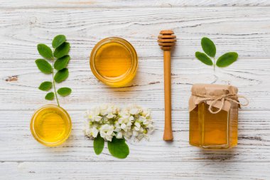 Akasya çiçekli ve yapraklı bal kavanozu. Taze bal üst görünüm düz yatıyordu.