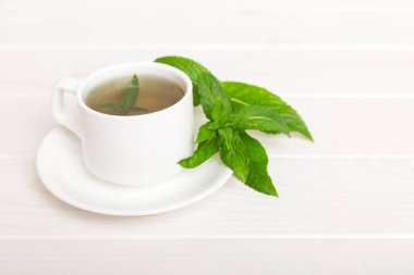 Arka planda bir fincan nane çayı. Fotokopi alanı ile taze nane görünümlü yeşil çay.