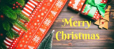 Mutlu Noeller mesajı. Köknar ağacından yapılmış Noel arkaplan manzarası, rulo ambalaj kağıdı ve ahşap zemin üzerindeki diğer dekorasyonlar. Fotokopi alanı olan yeni yıl konsepti.