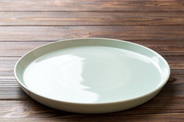 Ahşap zemin üzerinde boş mavi plakanın perspektif görüntüsü. Tasarımın için boş boşluk.