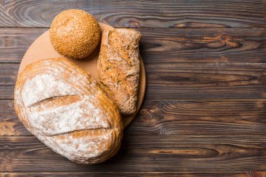 Tahtanın üzerinde beyaz ahşap zemine karşı taze pişmiş ekmek. Kopya alanı olan üst görünüm ekmeği.