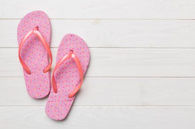 Flat lay composition with flip flops and seashell on colored background. Space for text top view.