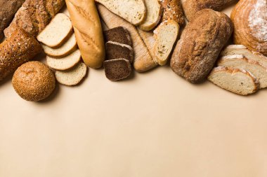 Ev yapımı doğal ekmek. Arka plan olarak farklı taze ekmek türleri, kopya alanı ile üst görünüm.