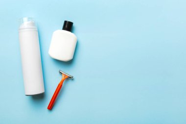 Tıraş Adam seti. Traş makinesi, havlu, losyon ve renkli arka planda tıraş köpüğü. Erkekler banyo aksesuarları üst görünüm.