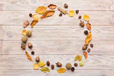 Masadaki kurumuş yapraklar, koniler ve meşe palamutlarından oluşan sonbahar kompozisyonu. Düz konum, üst görünüm, kopyalama alanı.