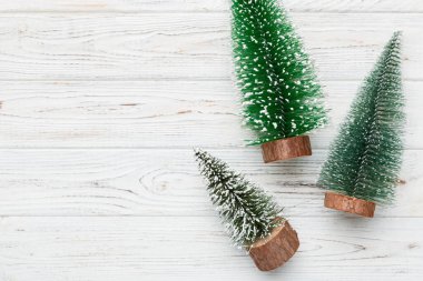 Renkli arka planda noel ağaçları olan düz kompozisyon. Kopyalama alanı olan üst görünüm.