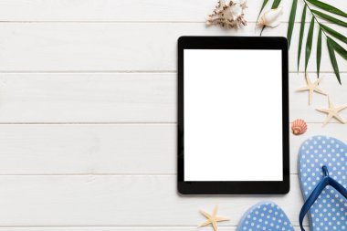 Renkli arka planda tablet ve plaj aksesuarlarıyla düz kompozisyon. Boş ekran ile tablet bilgisayarı kopyalama alanı ile maket.