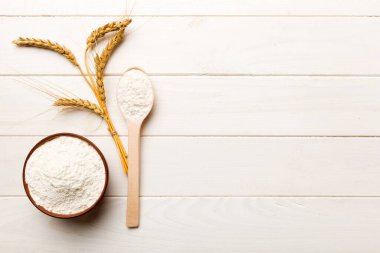 Tahta kasede buğday unu ve renkli arka planda buğday dikenleri. dünya buğday krizi.