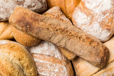 Ev yapımı doğal ekmek. Arka plan olarak farklı taze ekmek türleri, kopya alanı ile üst görünüm.