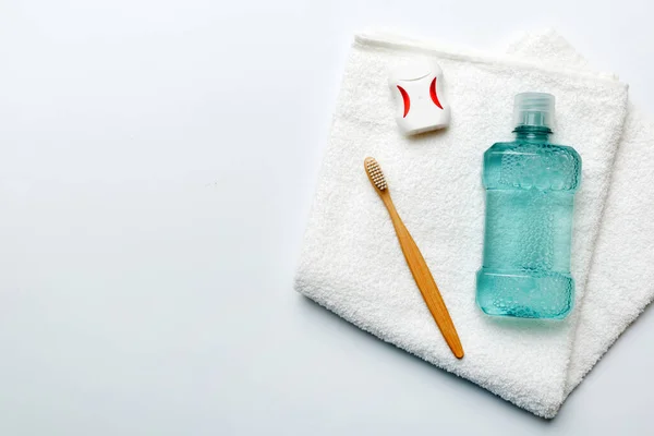 Mouthwash and other oral hygiene products on colored table top view with copy space. Flat lay. Dental hygiene. Oral care products and space for text on light background. concept.