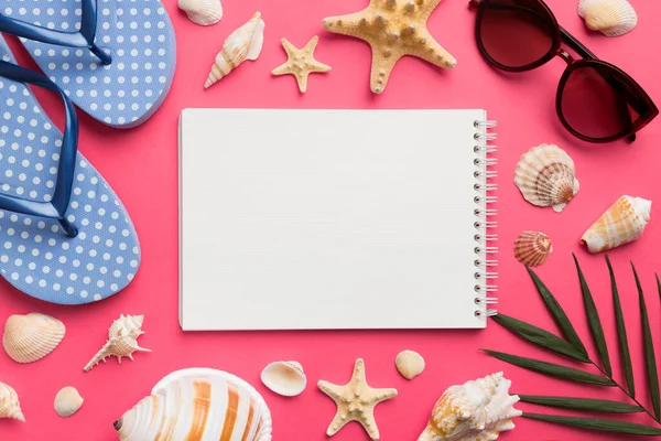 Blank writing book with summer beach accessories on background, copy space. Flat lay with copy space.