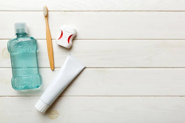 Mouthwash and other oral hygiene products on colored table top view with copy space. Flat lay. Dental hygiene. Oral care products and space for text on light background. concept.