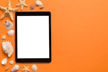 Renkli arka planda tablet ve plaj aksesuarlarıyla düz kompozisyon. Boş ekran ile tablet bilgisayarı kopyalama alanı ile maket.