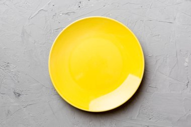 Çimento arka planındaki boş sarı plakanın üst görüntüsü. Tasarımın için boş boşluk.