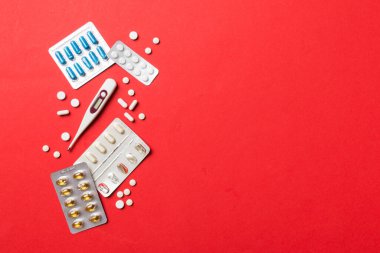 Masa arkasında koruyucu yüz maskeleri, cerrahi maskeler, ilaç hapları ve termometre. Coronavirus hastalığı. Corona virüsü konsepti. Metin için boşluk.