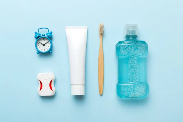 Mouthwash and other oral hygiene products on colored table top view with copy space. Flat lay. Dental hygiene. Oral care products and space for text on light background. concept.