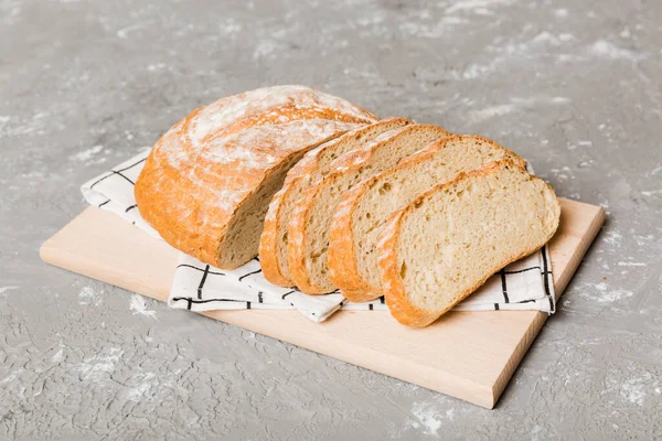 Assortment of freshly sliced baked bread with napkin on rustic table top view. Healthy unleavened bread. French bread slice.