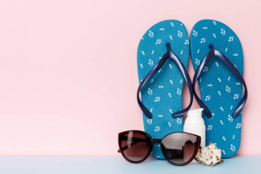 Plaj aksesuarları. Renkli arka planda parmak arası terlik ve denizyıldızı. Kopyalama alanı kullan.