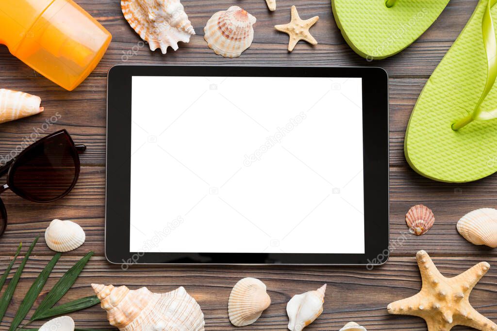 Flat lay composition with tablet and beach accessories on colored background. Tablet computer with blank screen mock up with copy space.