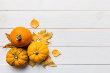 Sonbahar kompozisyonu. Masadaki kurumuş yapraklar ve diğer tasarım aksesuarlarından oluşan desen. Düz yatış, üst görünüm.