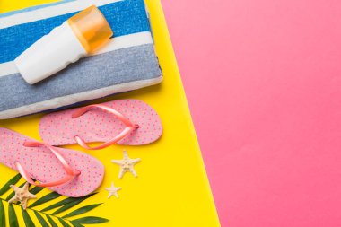 Plaj aksesuarları hasır şapka ve deniz kabuğu renkli masada. Yaz konsepti arka planı.