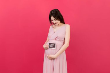 Bebek Sonografisi Fotoğraflı Tatlı Hamile Kadın Pozu Renkli Arkaplan. Hamilelik kavramı, jinekoloji, tıbbi test, annelik sağlığı.