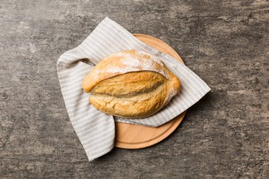 Tahtanın üzerinde beyaz ahşap zemine karşı taze pişmiş ekmek. Kopya alanı olan üst görünüm ekmeği.